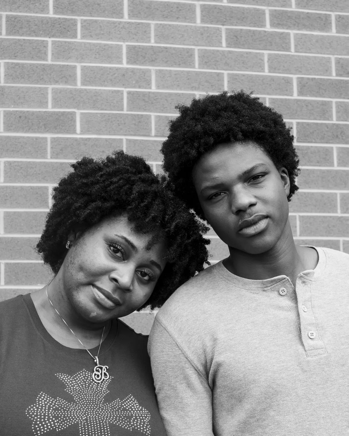 A mother and her teenage son leaning their heads together
