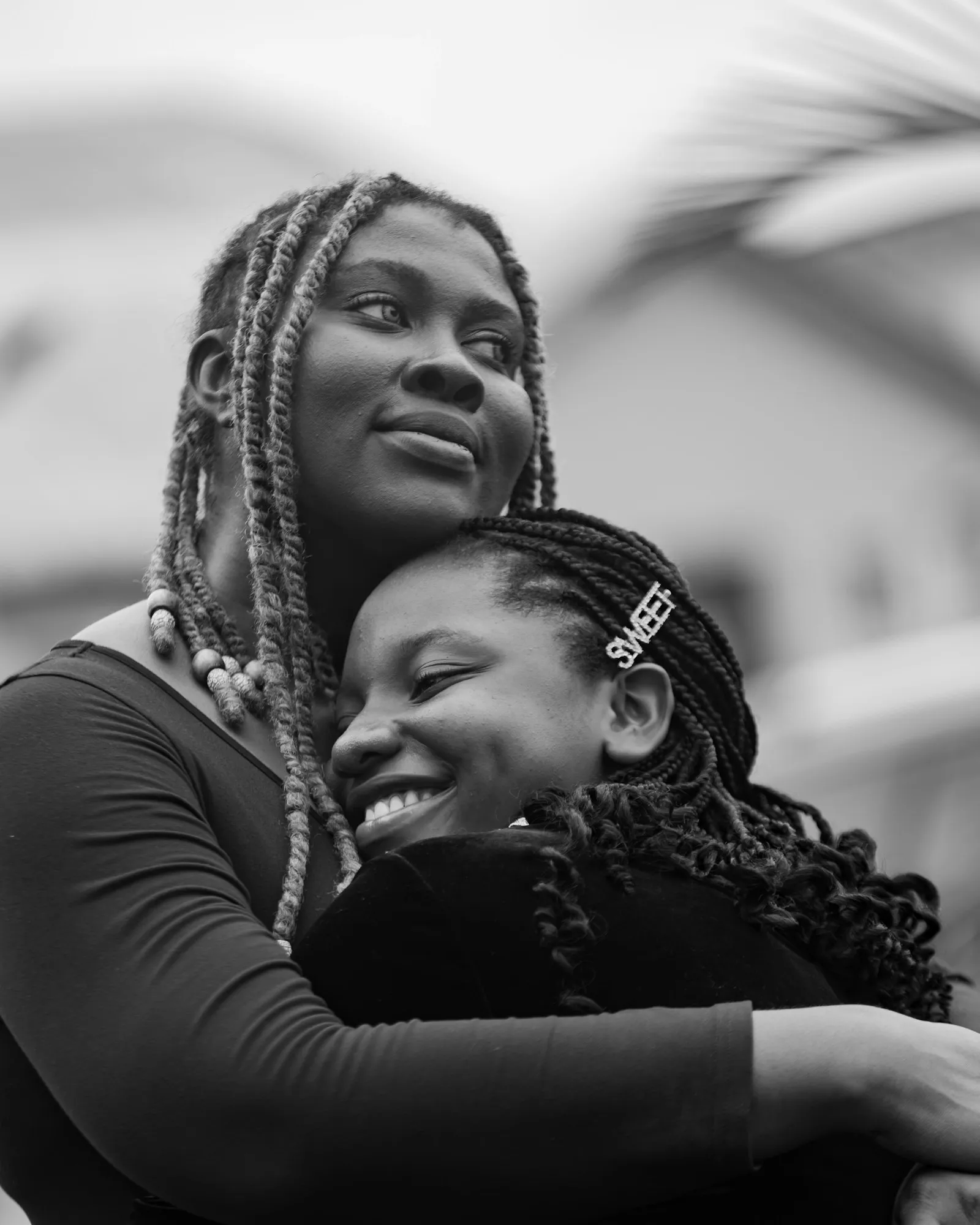 A mother holding her smiling teenage daughter in a warm embrace